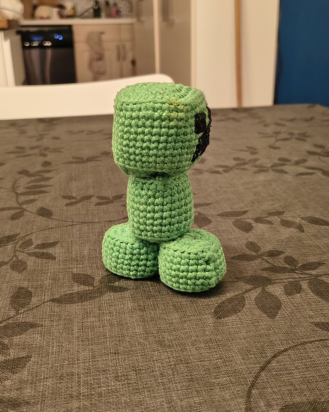 The finished Creeper amigurumi seen from behind, showing the square head and the block shapes of the body and feet