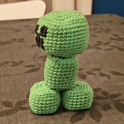 The finished crochet Creeper seen from the side, showing the cube head, the rectangular body and the block feet